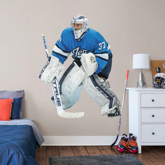 Life-Size Athlete + 2 Decals (51"W x 64"H) Opposing teams should be worried when they see Connor Hellebuyck in the goal, and now you can bring his epic defense skills to life in your own home with this Officially Licensed NHL removable wall decal. Pictured here ready to stop any puck that comes his way, this wall decal of Hellebuyck will make the perfect addition to your bedroom, office, or fan room, and it even makes a great gift for your favorite Jets fanatic!