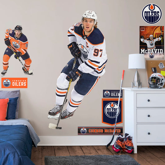 Life-Size Athlete + 8 Team Decals (39"W x 77"H) Widely considered to be among the best NHL players in the world, Edmonton Oilers centre and team captain Connor McDavid has cemented himself as a high-caliber player for the Oilers. Affectionately referred to as "Connor McSaviour" and the "Canadian Super Promise," this officially licensed NHL wall decal depicts the full frame of the Edmonton Oiler's 2015 first overall draft pick in his Away uniform.