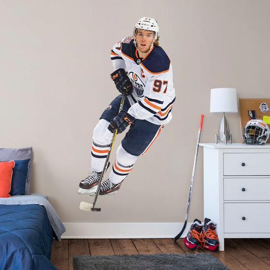 Life-Size Athlete + 2 Team Decals (39"W x 77"H) Widely considered to be among the best NHL players in the world, Edmonton Oilers centre and team captain Connor McDavid has cemented himself as a high-caliber player for the Oilers. Affectionately referred to as "Connor McSaviour" and the "Canadian Super Promise," this officially licensed NHL wall decal depicts the full frame of the Edmonton Oiler's 2015 first overall draft pick in his Away uniform.