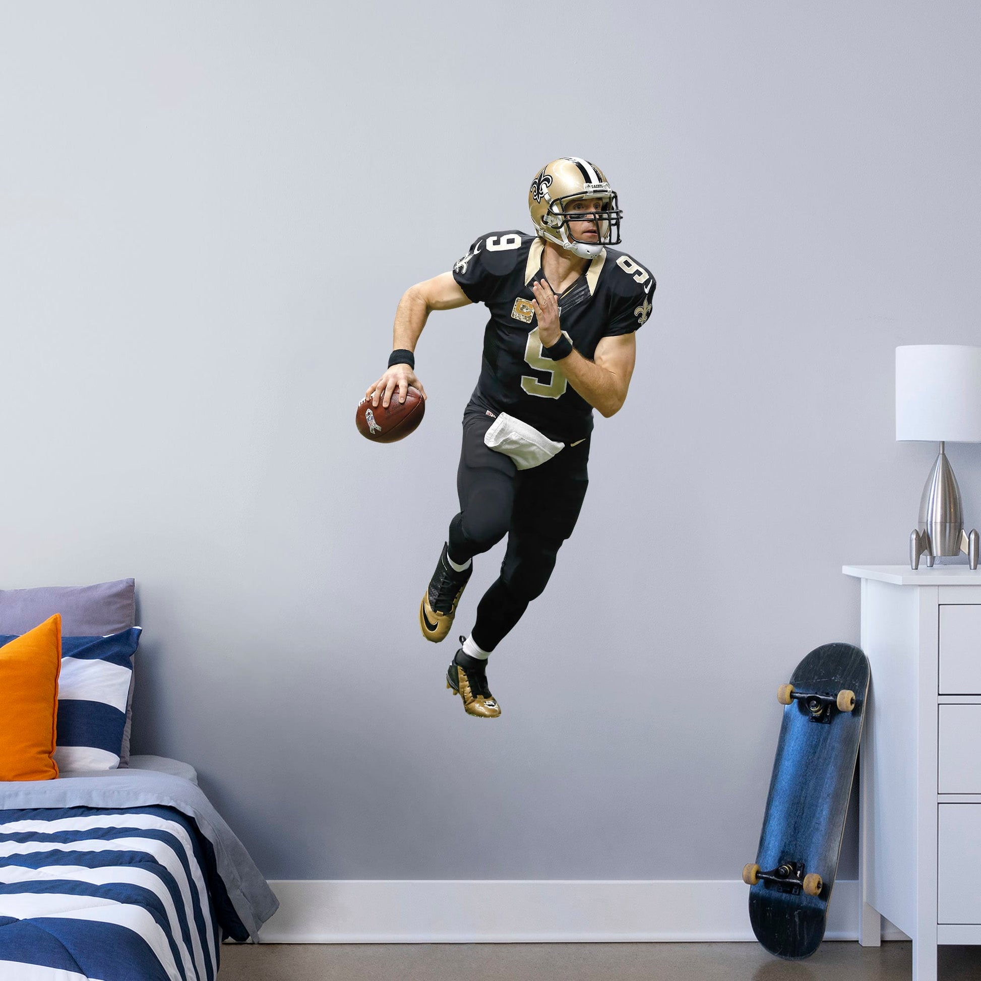 Giant Athlete + 1 Decals (20"W x 51"H) Super Bowl MVP, NFL Sportsman of the Year, and perennial fan favorite Drew Brees hustles across your man cave wall with this durable vinyl wall decal. Showcasing the Saints' signature black and old gold with the home game uniform, this decal turns your sports bar, bedroom, or dorm room into your personal Superdome. The reusable, high quality vinyl won't damage walls, making it the perfect choice if you need to take your Saints fandom on the road.