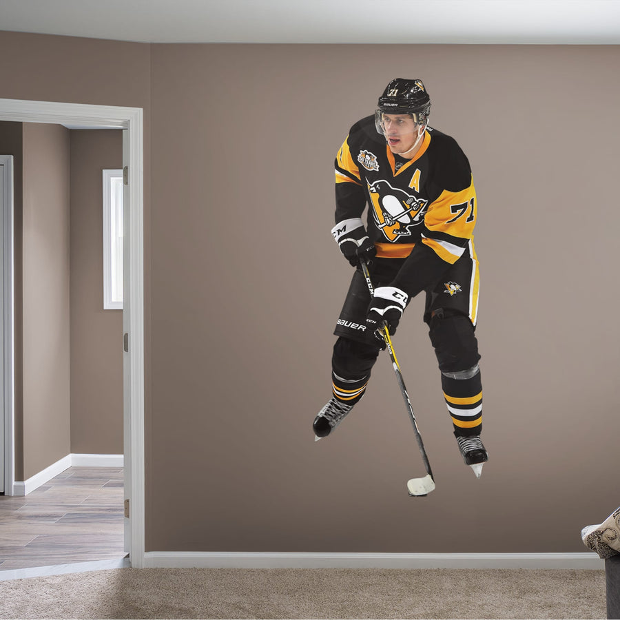 Athlete + 9 Team Decals (32"W x 77"H) Before he became alternate captain for the Pittsburgh Penguins, Evgeni Malkin made a name for himself playing for his hometown club in Russia, the Metallurg Magnitogorsk. Drafted by the Penguins during the second round of 2014's NHL draft, Geno has since become one of the Steel City team's star standouts, and this durable, reusable wall decal makes No. 71 a regular fixture around the office, bar or bedroom.