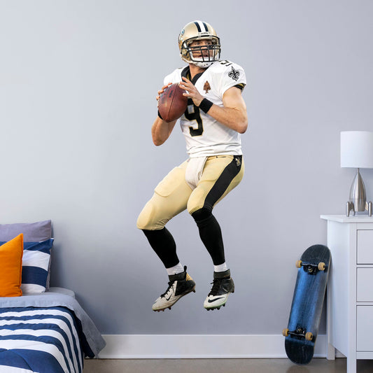 Life-Size Athlete + 1 Decals (29"W x 76"H) Let your favorite Saints quarterback go marching in your man cave, sports bar, or training space with this durable Drew Brees vinyl wall decal. The MVP of Super Bowl XLIV and one of the greatest quarterbacks of all time, Brees is a player you'll be proud to display in your personal Superdome. Should you call an audible and need to relocate, the high-quality decal is easy to remove and display in a new space.