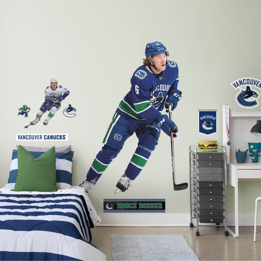 Life-Size Athlete + 12 Decals (56"W x 72"H) Everyone loves Brock Boeser, the first round pick from the 2015 draft, and now you can bring him to life in your bedroom, office, or fan room with this Officially Licensed NHL Wall Decal. Skating to life in the Canucks home uniform, this removable wall decal of Boeser is sure to bring some action to your home, no matter how many times you need to move and restick it!