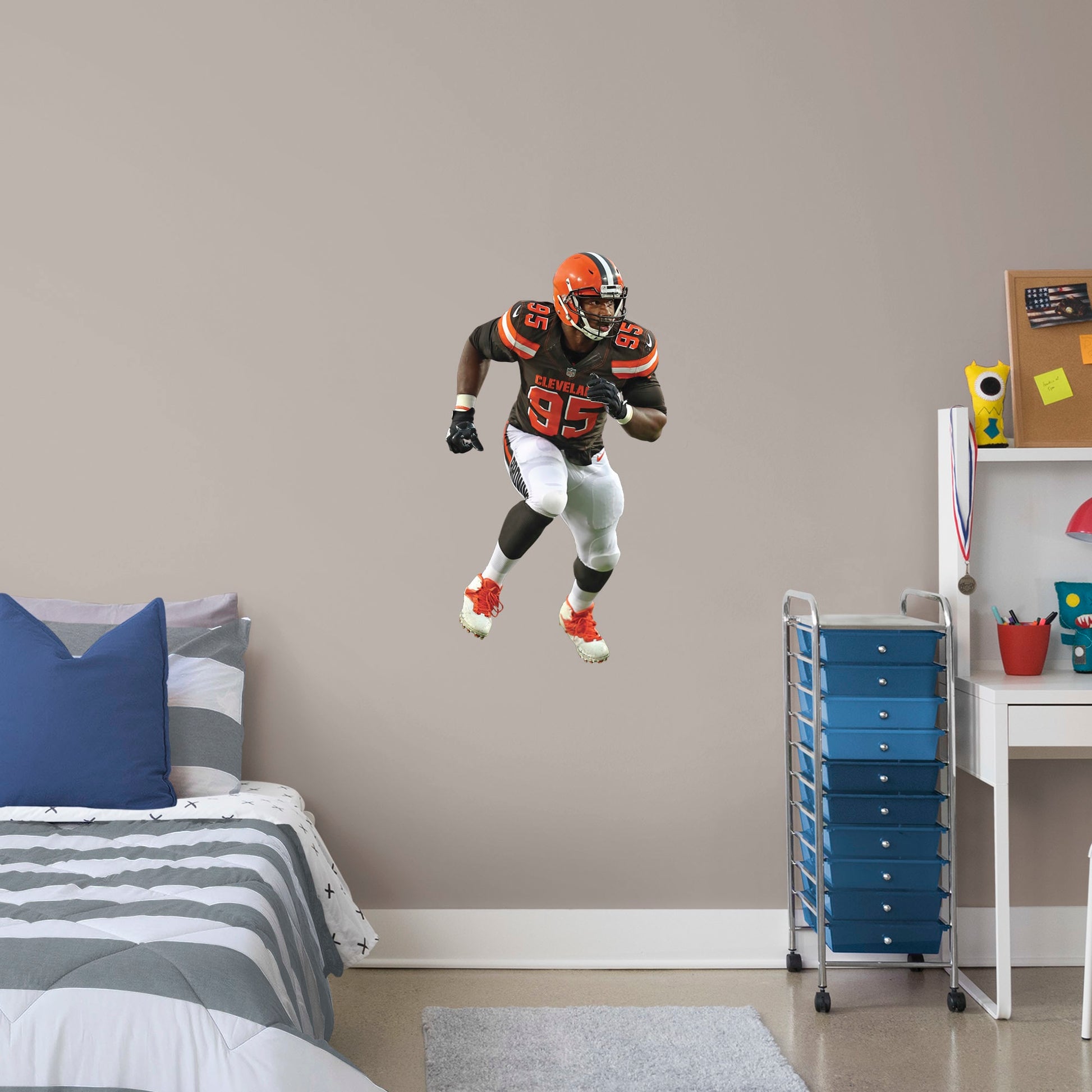X-Large Athlete + 2 Decals (21"W x 38"H) Invite Cleveland Browns defensive end Myles Garrett to your personal Dawg Pound with this durable vinyl wall decal. The 2017 first-round draft pick and 2018 Pro Bowl qualifier brings his defensive skills to your bedroom, office, and dog-friendly man cave. Browns Backers will appreciate the classic brown, white, and Cleveland orange, but you don't have to stay in Cleveland. Take this easily reusable decal on the road to wherever life takes you.