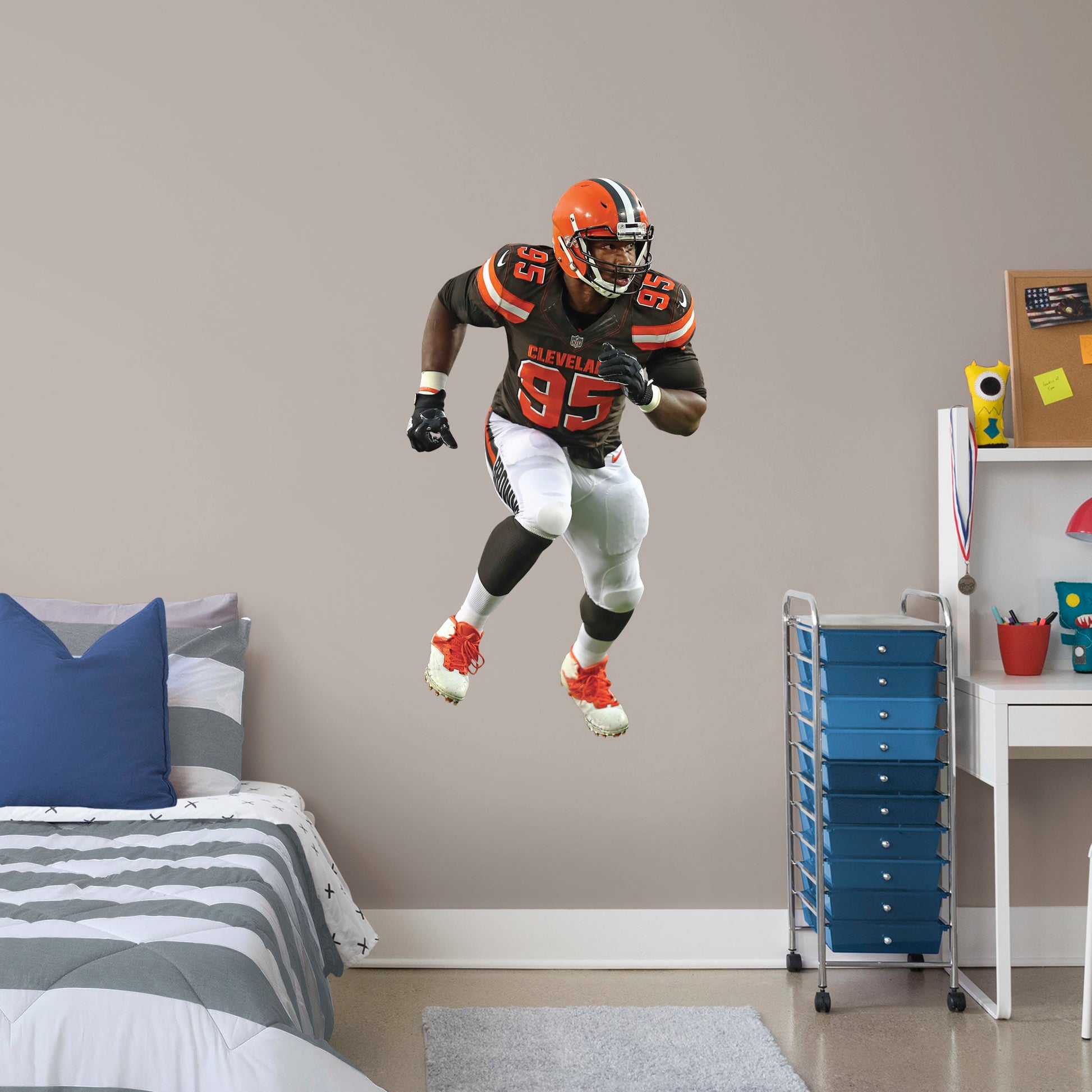 Giant Athlete + 2 Decals (27"W x 51"H) Invite Cleveland Browns defensive end Myles Garrett to your personal Dawg Pound with this durable vinyl wall decal. The 2017 first-round draft pick and 2018 Pro Bowl qualifier brings his defensive skills to your bedroom, office, and dog-friendly man cave. Browns Backers will appreciate the classic brown, white, and Cleveland orange, but you don't have to stay in Cleveland. Take this easily reusable decal on the road to wherever life takes you.