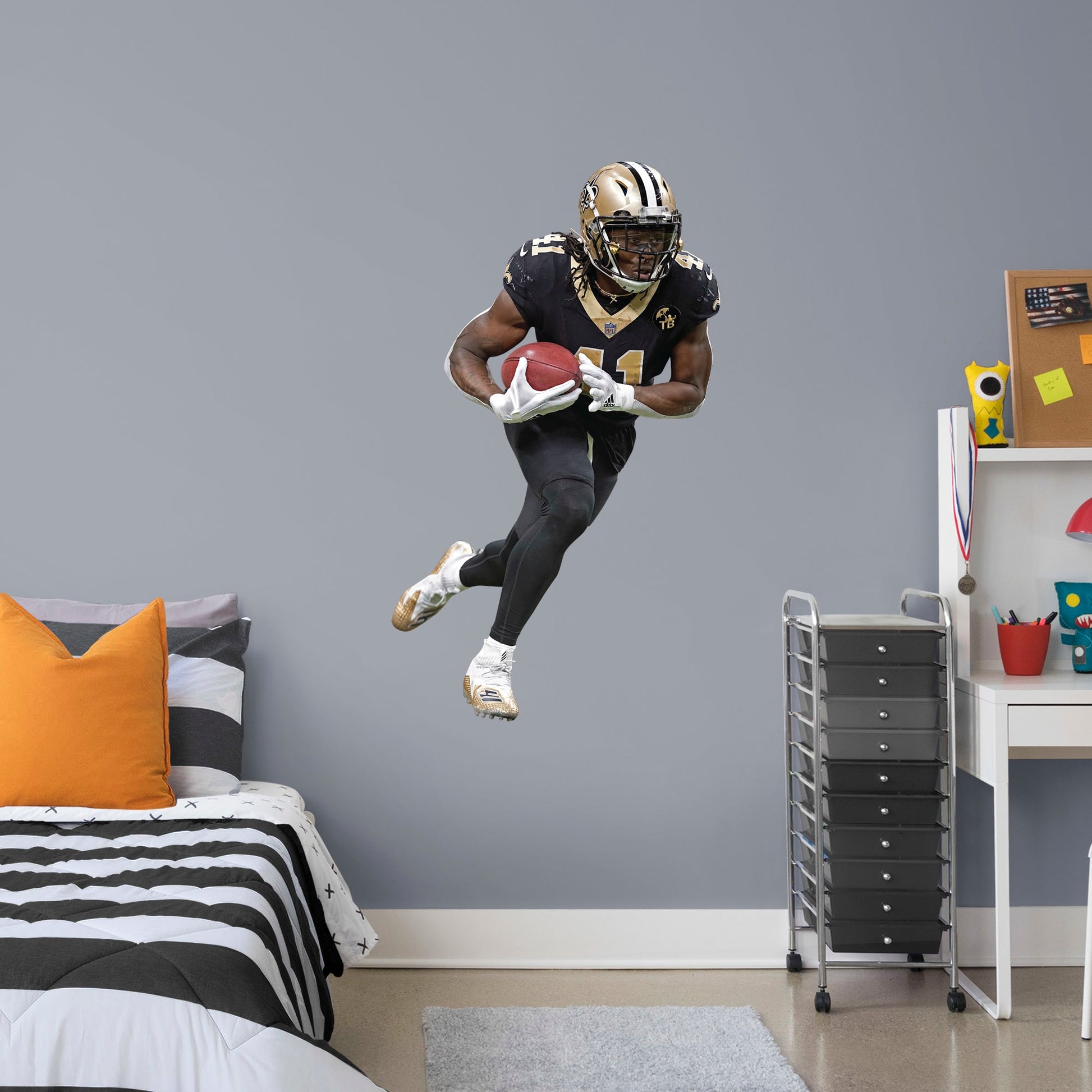 Life-Size Athlete + 10 Decals (43"W x 74"H) Who Dat! Running back Alvin Kamara of the New Orleans Saints had a stellar start to his NFL career with an impressive 32 TDs in his first two seasons - an MVP in the making. Deck your walls in black and gold with a high-grade vinyl decal of the Saints' #41. It won't fade or tear, so remove it and reuse it wherever you watch the big game. Geaux Saints!