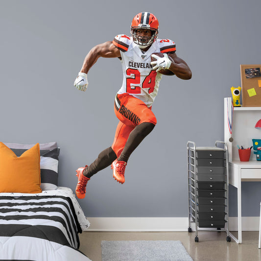 Life-Size Athlete + 2 Decals (48"W x 76"H) Heir to a Cleveland running back a tradition that includes the legendary Jim Brown, Nick Chubb is the new Browns powerhouse. Blessed with a blend of power, balance, and speed, the man they call Old School is a nightmare for AFC North foes. Now Dawg Pound fans can salute the former Georgia All-American with this removable wall decal collection. The premium vinyl decals are as durable as Chubb himself and ready to charge through a bonus room, bedroom, or dorm. Woof!