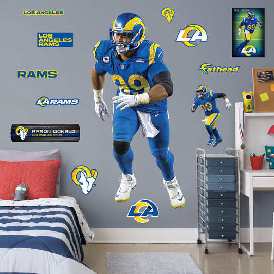 Life-Size Athlete + 12 Decals (37"W x 77"H) Rams fans know and love Aaron Donald as the star defensive tackle from their favorite team and now they can bring home that Los Angeles pride with an Aaron Donald Removable Wall Decal Set! This wall decal is vibrant and durable so you'll be able to stick it and move it over and over again. Go Rams!