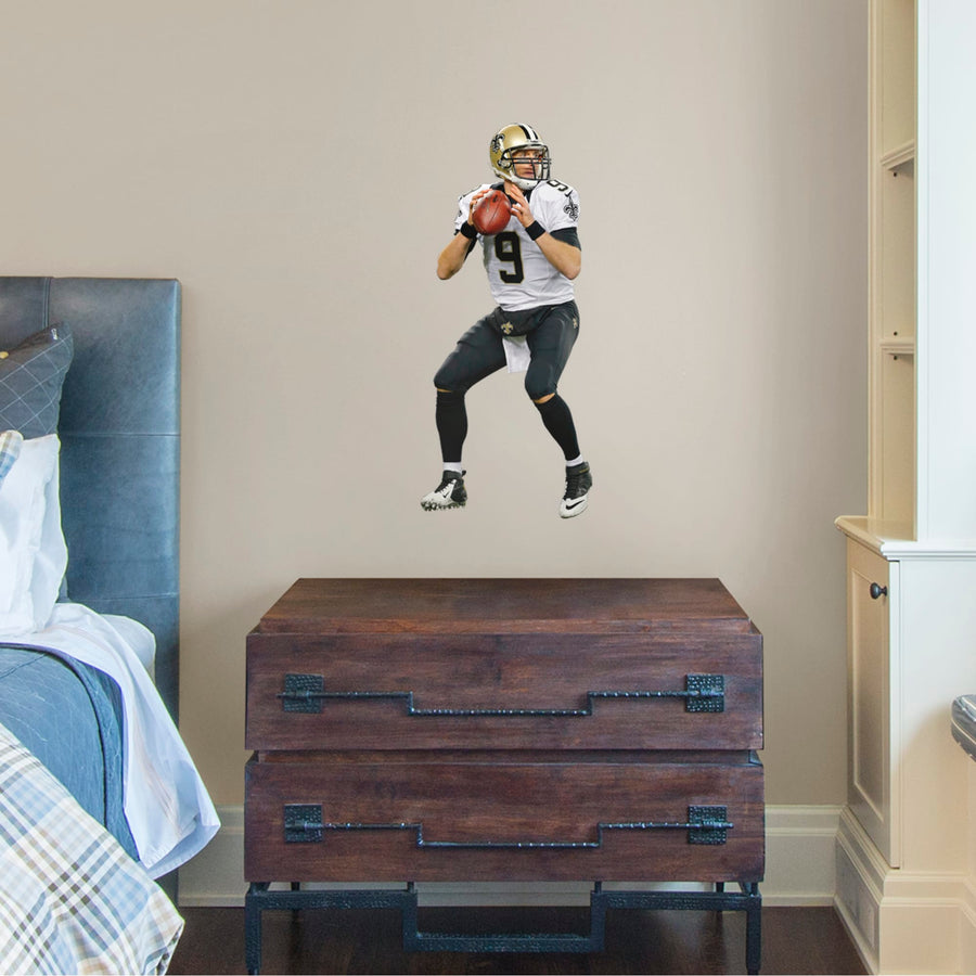 Bring the action of the NFL into your home with a wall decal of Drew Brees! High quality, durable, and tear resistant, you'll be able to stick and move it as many times as you want to create the ultimate football experience in any room!
