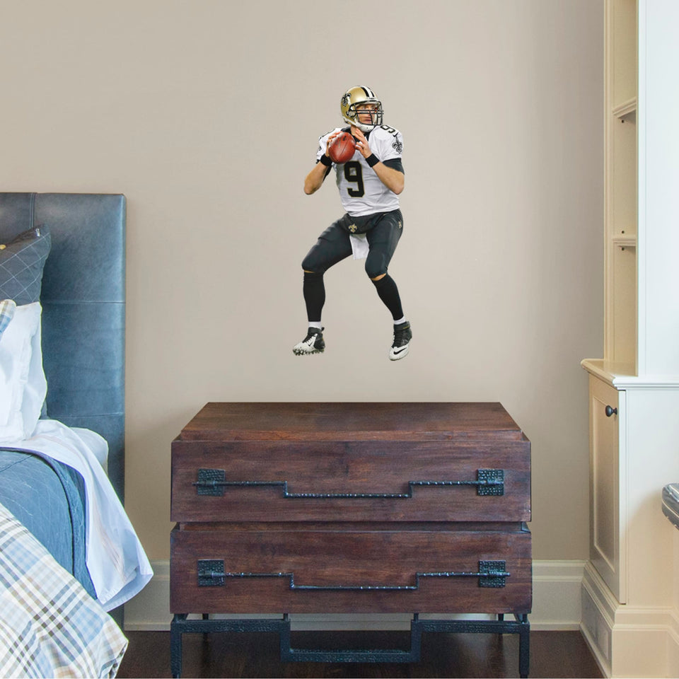 Bring the action of the NFL into your home with a wall decal of Drew Brees! High quality, durable, and tear resistant, you'll be able to stick and move it as many times as you want to create the ultimate football experience in any room!