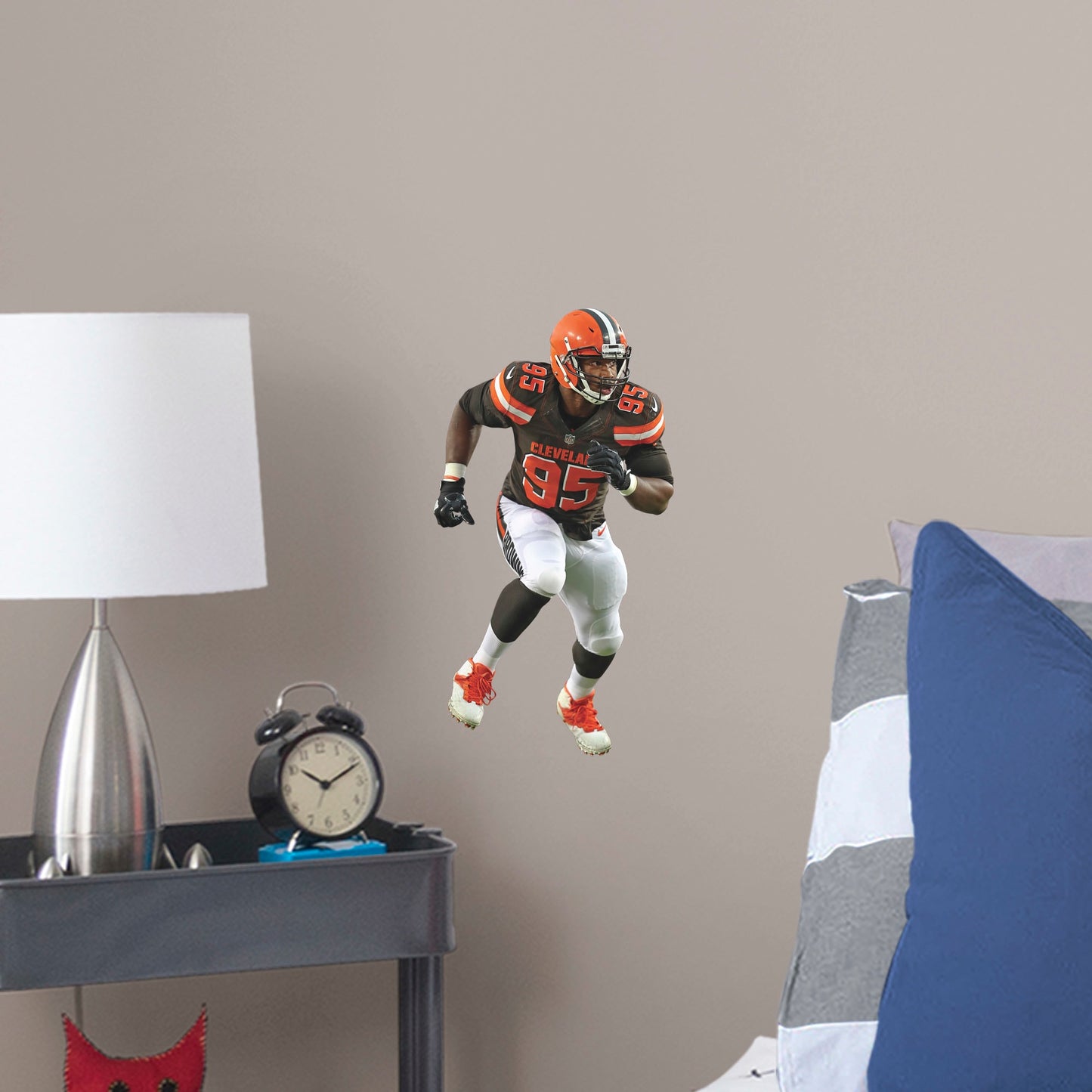 Large Athlete + 2 Decals (9"W x 16"H) Invite Cleveland Browns defensive end Myles Garrett to your personal Dawg Pound with this durable vinyl wall decal. The 2017 first-round draft pick and 2018 Pro Bowl qualifier brings his defensive skills to your bedroom, office, and dog-friendly man cave. Browns Backers will appreciate the classic brown, white, and Cleveland orange, but you don't have to stay in Cleveland. Take this easily reusable decal on the road to wherever life takes you.