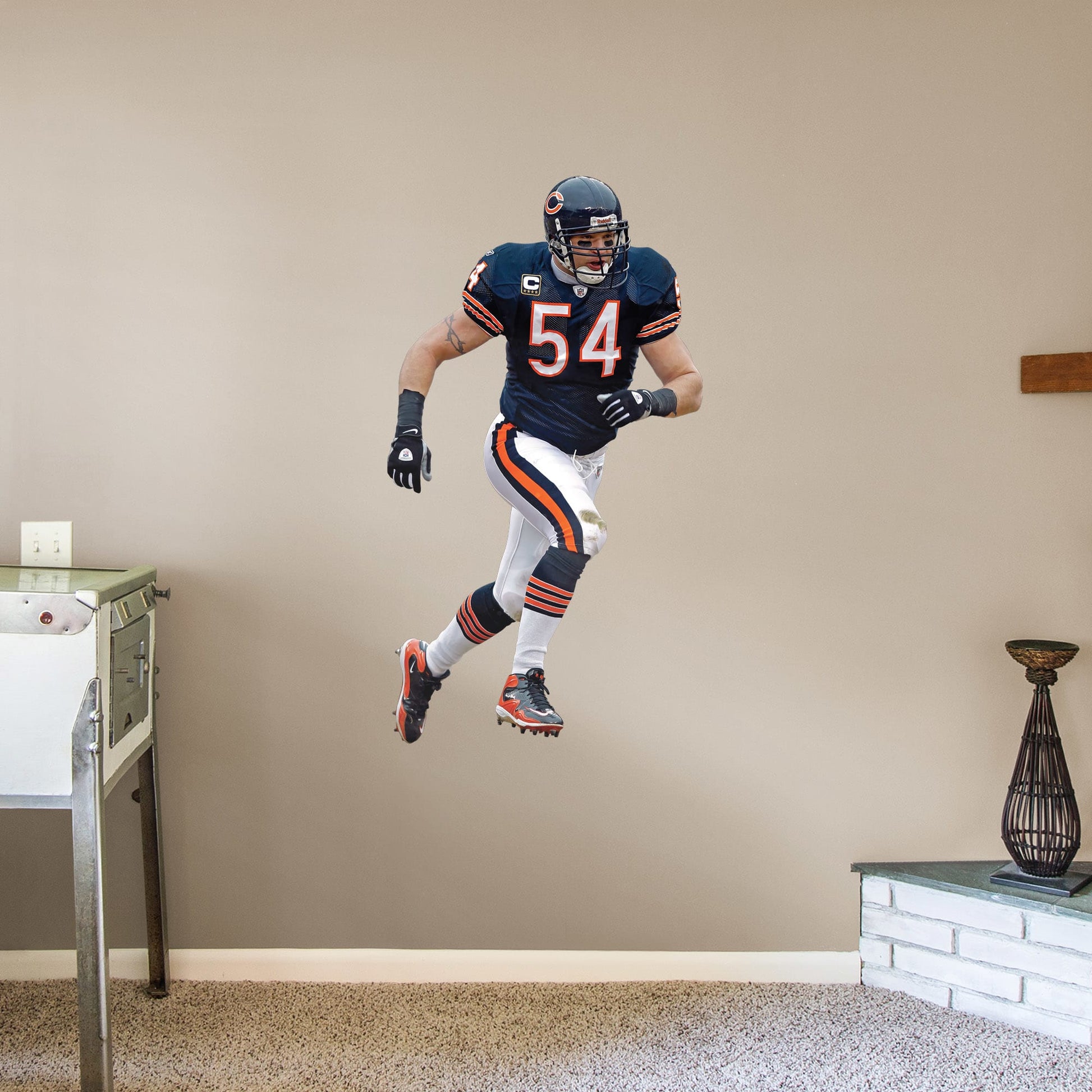 Giant Athlete + 2 Decals (28"W x 51"H) For 13 years, the Chicago Bears watched #54 earn his place as one of the Top 100 Bears of All time. Rep the navy blue and burnt orange with a high-grade vinyl decal of Da Bears legend Brian Urlacher. Removable, reusable, and tear-resistant, this Hall of Famer is great for bedrooms, man caves, or even as a temporary party decoration. Bear down, Chicago Bears!