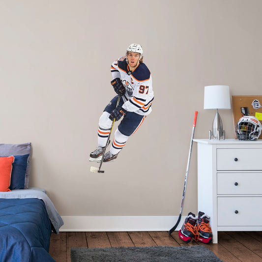 Giant Athlete + 2 Team Decals (26"W x 51"H) Widely considered to be among the best NHL players in the world, Edmonton Oilers centre and team captain Connor McDavid has cemented himself as a high-caliber player for the Oilers. Affectionately referred to as "Connor McSaviour" and the "Canadian Super Promise," this officially licensed NHL wall decal depicts the full frame of the Edmonton Oiler's 2015 first overall draft pick in his Away uniform.